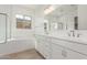 Bright bathroom features dual sinks, a soaking tub, and a glass-enclosed shower at 24134 N 172Nd Ave, Surprise, AZ 85387