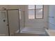 Bright white bathroom featuring glass enclosed shower, soaker tub, subway tile, and a large window at 24134 N 172Nd Ave, Surprise, AZ 85387