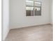 Bright, neutral bedroom with wood-look tile flooring and a view through a window at 24134 N 172Nd Ave, Surprise, AZ 85387
