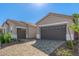 Two car garages with brick paved driveways, desert landscaping, and grey doors at 24134 N 172Nd Ave, Surprise, AZ 85387