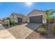 Two car garages with brick paved driveways, desert landscaping, and grey doors at 24134 N 172Nd Ave, Surprise, AZ 85387