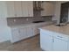 Modern kitchen featuring white cabinets, gray backsplash, stainless steel appliances, and a functional center island at 24134 N 172Nd Ave, Surprise, AZ 85387