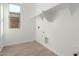 Bright laundry room with tiled floors, open shelving, and a window for natural light at 24134 N 172Nd Ave, Surprise, AZ 85387