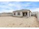 View of the backyard with a covered patio and block fence, ready for landscaping at 24408 W Ripple Rd, Buckeye, AZ 85326