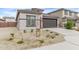 Beautiful front exterior of home with 2-car garage, desert landscaping, and neutral paint at 24408 W Ripple Rd, Buckeye, AZ 85326
