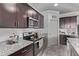 Well-equipped kitchen featuring stainless steel appliances, granite countertops, and dark wood cabinets at 24408 W Ripple Rd, Buckeye, AZ 85326