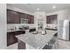 Modern kitchen featuring dark wood cabinets, stainless appliances, granite countertops, and island with breakfast bar at 24408 W Ripple Rd, Buckeye, AZ 85326