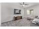 Cozy living room with a modern ceiling fan, plush carpet, and sliding barn door media center at 24408 W Ripple Rd, Buckeye, AZ 85326
