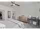 Bright main bedroom featuring a ceiling fan, dresser, desk, and a stylish decorative mirror at 24408 W Ripple Rd, Buckeye, AZ 85326
