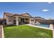 Inviting backyard with artificial turf, covered patio, pool, and comfortable seating at 26978 N 74Th Ln, Peoria, AZ 85383
