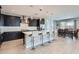 Stylish kitchen featuring dark cabinetry, a breakfast bar with seating, and stainless steel appliances at 26978 N 74Th Ln, Peoria, AZ 85383