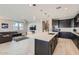 Open-concept kitchen with a large island, stainless steel appliances, and seamless flow to the living area at 26978 N 74Th Ln, Peoria, AZ 85383
