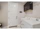Functional laundry area with washer, dryer, wall-mounted cabinets, and tile flooring at 26978 N 74Th Ln, Peoria, AZ 85383