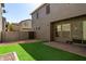 Backyard featuring a paver patio, a small strip of synthetic grass, and a rock border at 3450 S Falcon Dr, Gilbert, AZ 85297