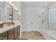 Bright bathroom featuring a double vanity with granite countertops, walk-in shower, and white cabinets at 3690 E Blue Spruce Ln, Gilbert, AZ 85298