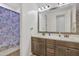 Bathroom with double sink vanity, decorative mirror, and shower with shell curtain at 3690 E Blue Spruce Ln, Gilbert, AZ 85298