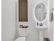 Bright bathroom featuring a pedestal sink, modern lighting, and toilet with shelving at 3690 E Blue Spruce Ln, Gilbert, AZ 85298