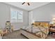 Cozy bedroom featuring a ceiling fan, large window with plantation shutters, and neutral colored walls at 3690 E Blue Spruce Ln, Gilbert, AZ 85298