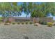 Attractive community entrance with stone signage, mature landscaping, and manicured gravel creating a welcoming first impression at 3690 E Blue Spruce Ln, Gilbert, AZ 85298
