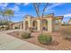 Charming single-story home featuring a two-car garage, arched entryway, and well-maintained desert landscaping at 3690 E Blue Spruce Ln, Gilbert, AZ 85298