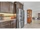 Modern kitchen featuring stainless steel refrigerator, granite countertops and dark wood cabinetry for ample storage at 3690 E Blue Spruce Ln, Gilbert, AZ 85298