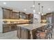 Spacious kitchen featuring dark wood cabinetry, granite countertops, a large center island, and pendant lighting at 3690 E Blue Spruce Ln, Gilbert, AZ 85298