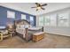 Stylish main bedroom features a blue accent wall, a ceiling fan, a king-size bed, and plenty of natural light at 3690 E Blue Spruce Ln, Gilbert, AZ 85298