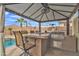 Outdoor kitchen with bar seating, grill, and counter space, perfect for entertaining at 3690 E Blue Spruce Ln, Gilbert, AZ 85298