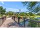 A charming wooden bridge leads to a playground with water features and shady trees, inviting neighborhood surroundings at 3690 E Blue Spruce Ln, Gilbert, AZ 85298