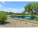 Scenic community pond featuring cascading waterfalls, lush landscaping, and a peaceful walking path at 3690 E Blue Spruce Ln, Gilbert, AZ 85298