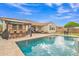 Backyard pool with outdoor kitchen, lounge seating, and landscaping, ideal for relaxation and gatherings at 3690 E Blue Spruce Ln, Gilbert, AZ 85298