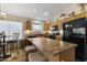Spacious kitchen offers a center island, wood cabinets, black appliances, and stylish lighting at 40729 W Coltin Way, Maricopa, AZ 85138