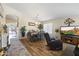 Open-concept living space showcases wood floors, a dining area, and a comfortable recliner with a tv at 40729 W Coltin Way, Maricopa, AZ 85138