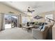 Bright living room featuring a large sectional, ceiling fan, and sliding glass doors leading to a pool area at 40729 W Coltin Way, Maricopa, AZ 85138