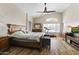 Main bedroom showcasing hardwood floors, ceiling fan, and an arched window at 40729 W Coltin Way, Maricopa, AZ 85138