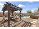 Inviting backyard featuring pergola with outdoor seating, pool, and hot tub surrounded by a gravel landscape at 40729 W Coltin Way, Maricopa, AZ 85138