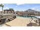 Backyard features a hot tub next to the sparkling pool, an outdoor dining area, and lush landscaping creating a private oasis at 40729 W Coltin Way, Maricopa, AZ 85138
