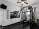 Home exercise room featuring a mirror, pull-up rig, mounted TV, and rubber floor at 4144 E Blossom Ct, Gilbert, AZ 85297