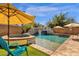 Outdoor pool area featuring a hot tub, waterfall feature, tanning ledge and patio umbrellas at 4144 E Blossom Ct, Gilbert, AZ 85297