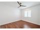 This bedroom has wood floors, white walls, and a ceiling fan, providing a blank slate for personalization at 4402 E Montecito Ave, Phoenix, AZ 85018