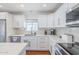 Modern kitchen featuring white cabinets, stainless steel appliances, marble countertops, and a window over the sink at 4402 E Montecito Ave, Phoenix, AZ 85018