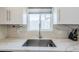 Close-up of the kitchen sink, featuring marble countertops, stainless steel faucet, and white cabinets at 4402 E Montecito Ave, Phoenix, AZ 85018