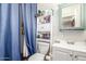 Functional bathroom with a toilet, vanity, and a blue shower curtain at 4521 W Clarendon Ave, Phoenix, AZ 85031