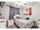Comfortable bedroom with white furniture, ceiling fan, and art pieces on the wall at 4521 W Clarendon Ave, Phoenix, AZ 85031