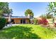 Lush green backyard with mature trees, solar panels and blue patio doors at 4839 E Marilyn Rd, Scottsdale, AZ 85254