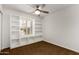 Bright bedroom featuring white walls, built-in shelving around the window, and a ceiling fan at 4839 E Marilyn Rd, Scottsdale, AZ 85254