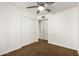 Bedroom with built-in closet, ceiling fan, neutral carpet, and white walls at 4839 E Marilyn Rd, Scottsdale, AZ 85254