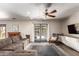 Spacious living room featuring a comfortable sofa, ceiling fan, and sliding glass doors to the backyard at 4839 E Marilyn Rd, Scottsdale, AZ 85254
