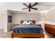 Updated bedroom featuring a wooden bed frame with stylish blue bedding, ceiling fan, and wooden floors at 4839 E Marilyn Rd, Scottsdale, AZ 85254