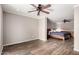 Spacious bedroom features wood-look tile, ceiling fan, and sleeping area with updated bed and linens at 4839 E Marilyn Rd, Scottsdale, AZ 85254
